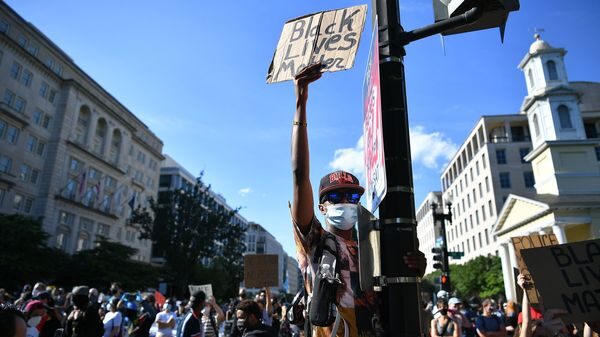 Des manifestants protestant contre la mort de George Floyd brandissent des pancartes près de la Maison Blanche le 1er juin à Washington, D.C.