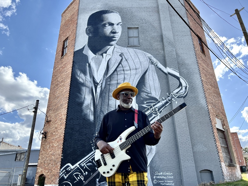 Tacuma devant la fresque de John Coltrane dans la ville de naissance de Coltrane, Hamlet, NC